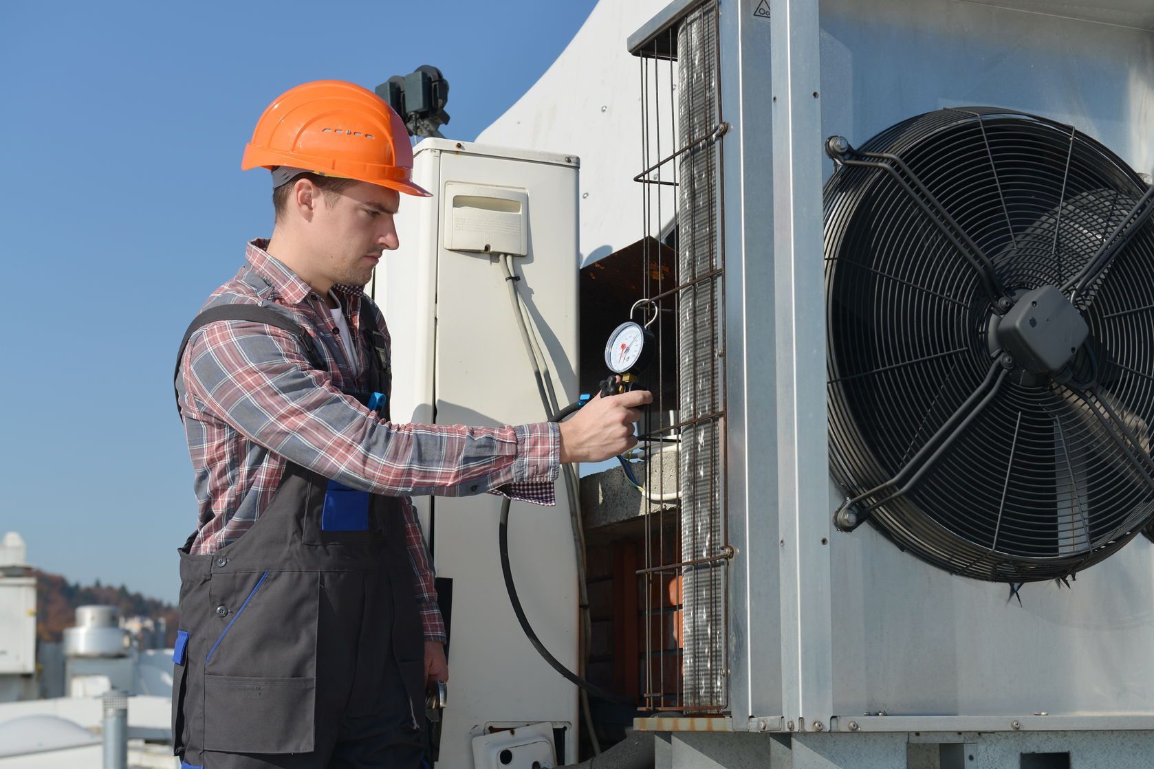 Technicien HVAC effectuant un contrôle de pression sur une unité de climatisation
